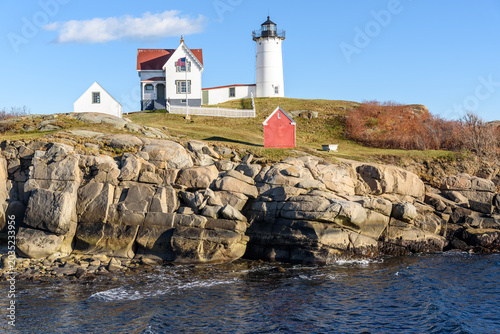 View of Nubble lighthouse on a rocky outcrop a clear autumn day. Cape Neddick, ME, USA.