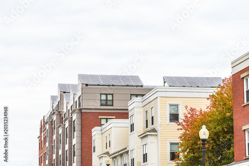 Energy efficient apartment buildings with the rooftops covered with solar panels on a cloudy autumn day