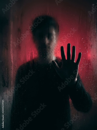 Silhouette behind wet glass, red moody atmosphere
