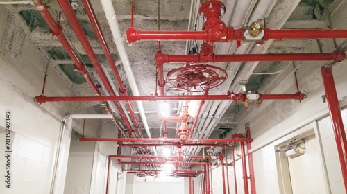 Industrial Ceiling with Red Fire Sprinkler System and Piping in a Commercial Building Hallway, Designing for Safety and Efficiency with Modern Infrastructure Elements