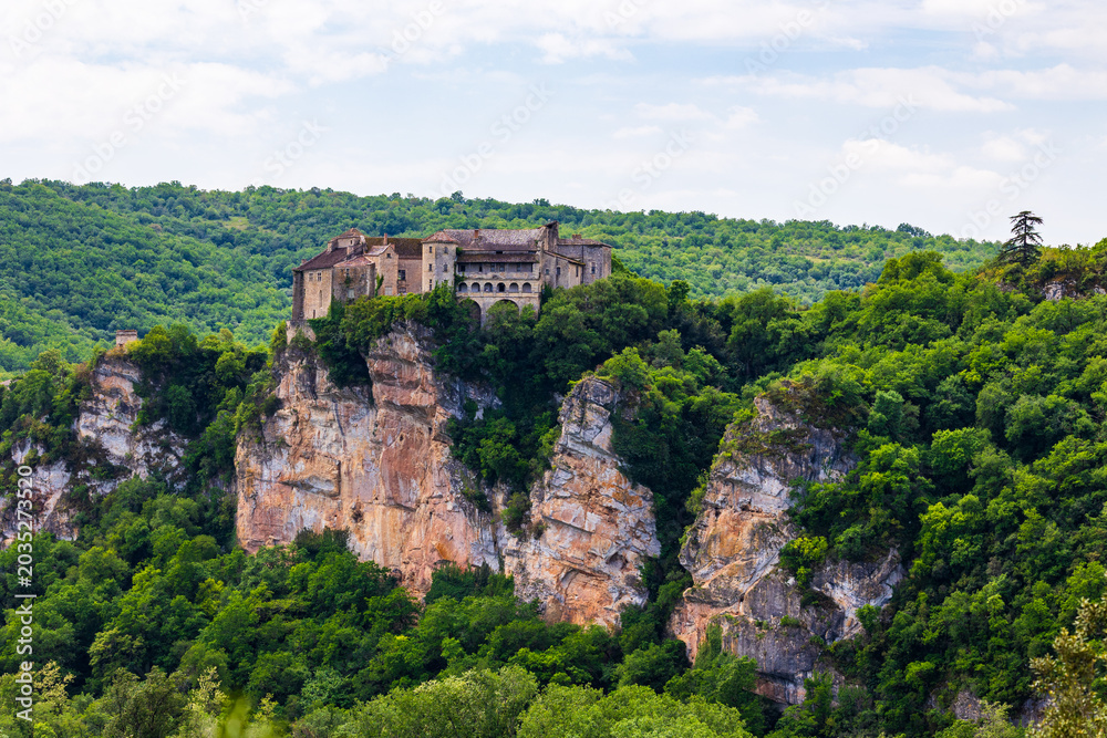 Fototapeta premium Bruniquel Castles at the top of a limestone cliff overlooking the Gorges de l'Aveyron and the Grésigne forest seen from the opposite slope