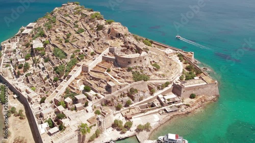 Aerial push in view of Spinalonga fortress island and turquoise sea
