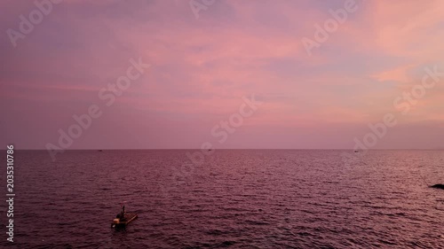 Dramatic Pink Sunset Over Calm Ocean with Small Fishing Boat