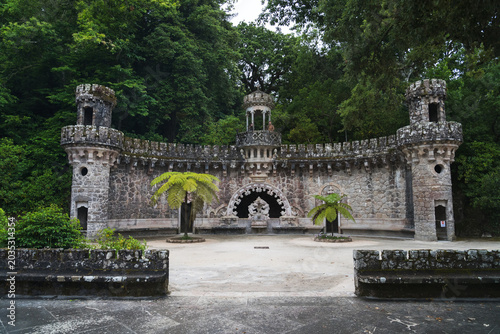 Tableau sur toile A grand, historic Portuguese architectural gate framed by lush, verdant park fol