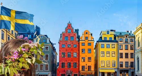 Frau mit Blumenkranz vor HistorischenFassaden in der Altstadt von Stockholm i...