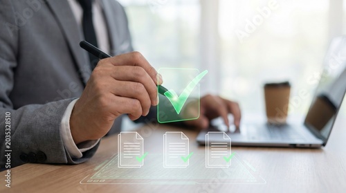 Fotografie Businessman in suit signs document with digital e signature on laptop screen in