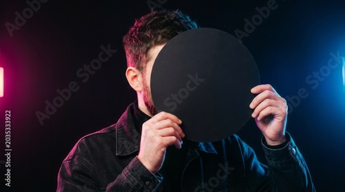 Person Holding Black Circle in Studio Lighting