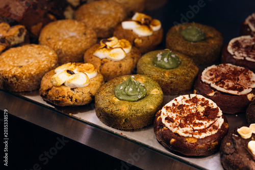 Assorted crumble cookies displayed in a bakery showcase.