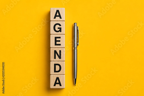 Agenda planning concept with wooden alphabet blocks and pen representing organized scheduling productivity and effective business management practices today