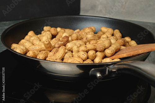 Roasting fresh peanuts in a skillet for a delightful snack experience