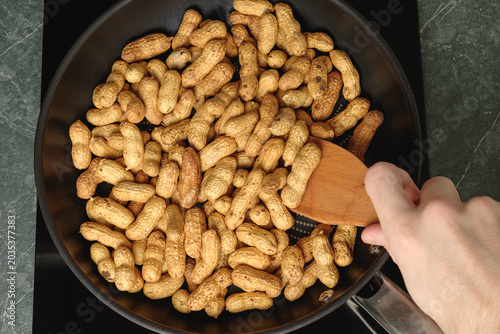 Roasting fresh peanuts in a skillet, a warm and tasty kitchen delight