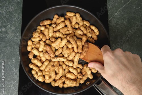 Warm and crunchy peanuts roasting in a skillet, ready for snacking joy