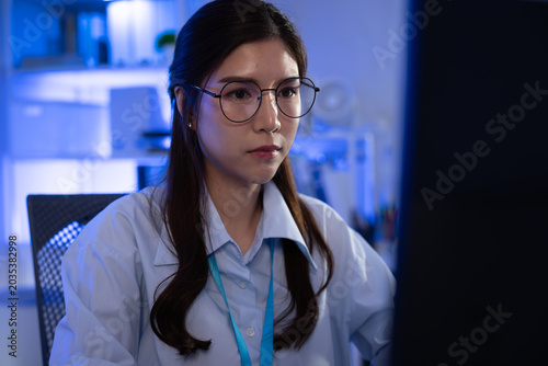 Woman eyeglasses computer office working focused professional woman wearing eyeglasses working on computer in modern office at night, focused and calm, blue light, technology workspace, copy space