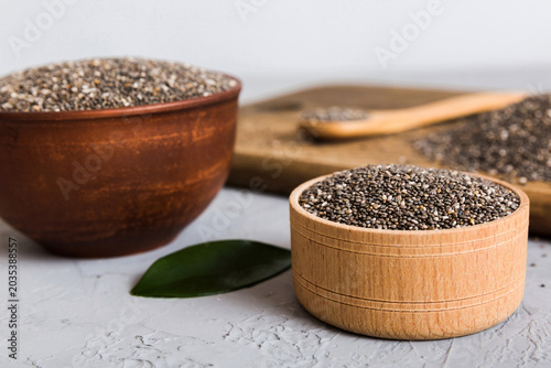 Chia seeds in bowl and spoon on colored background. Healthy Salvia hispanica in small bowl. Healthy superfood