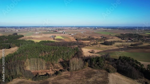 Forward drone flight above forest and agricultural countryside