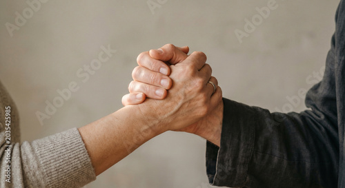 Close up of two people shaking hands or wrestling. Support and teamwork