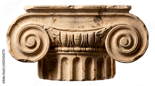 An ancient Ionic column capital, weathered and cracked, showcasing intricate volutes and ornate detailing