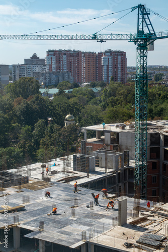 Residential building high-rise construction site on summer cityscape background