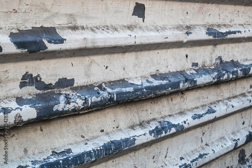 Close-up of peeling paint on corrugated metal siding. Industrial surface with visible rust and decay