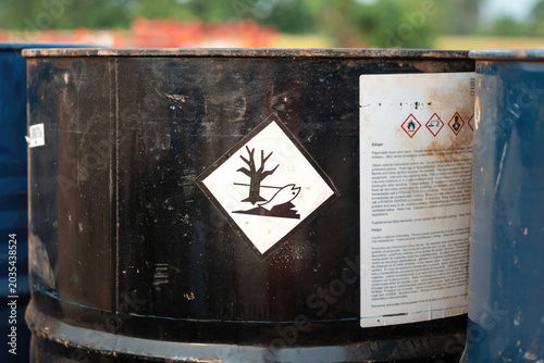 An environment hazard warning sign (GHS) on the chemical metal barrel. Safety sign for industrial product, close-up with selective focus.