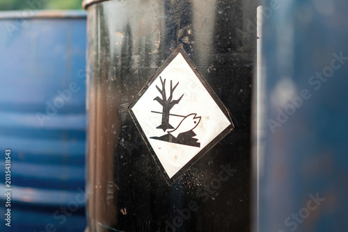 An environment hazard warning sign (GHS) on the chemical metal barrel. Safety sign for industrial product, close-up with selective focus.