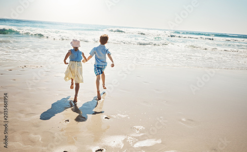 Family, kids and holding hands with running at beach for summer holiday, adventure or bonding. Siblings, back of children and energy at seaside for weekend fun, freedom or playing together with space