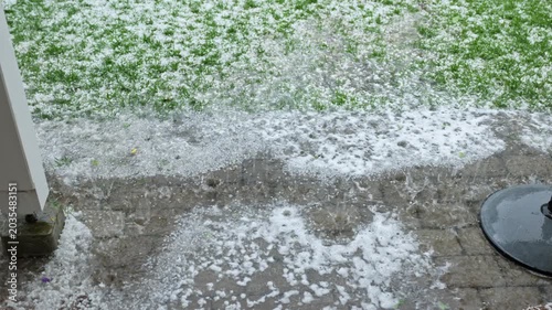 Close up view of severe hailstorm with heavy rain flooding backyard patio and garden. Sweden.