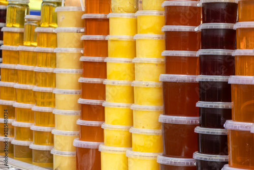 Canvas-taulu Stacked containers of natural organic honey in various shades, showcasing a rich