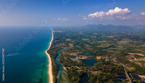 Fotografía High altitude drone view of coastal landscape with mountains, sea and fields