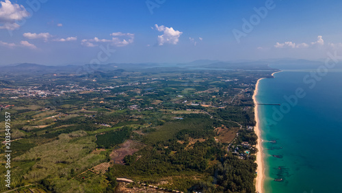 Foto High altitude drone view of coastal landscape with mountains, sea and fields