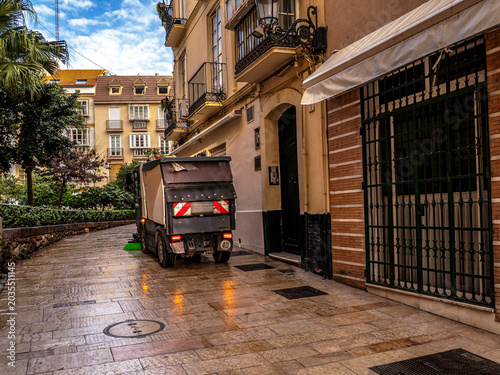 Canvas Print Street Sweeper Truck Cleaning Narrow Alley with Wet Pavement and Historic Reside