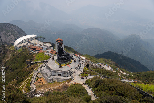 Tableau sur toile Great buddha statue sits on fansipan mountain, surrounded by walking paths and b