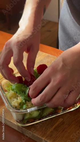 Hand Adding Arugula to Couscous Salad in Glass Container Healthy Food Preparation Fresh Organic Salad Cooking Process Nutritional Meal Clean Eating Lifestyle Kitchen Close Up 4K Video