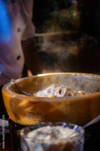 Pasta preparation with chef at restaurant during evening service