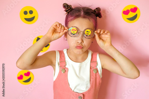 Canvas Print The girl lifts her glasses with emoticons pasted on the lenses, languidly pouting with negative emotions