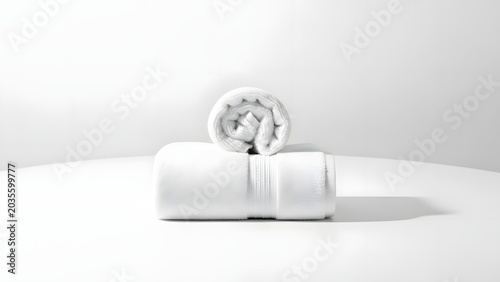 Two white towels are neatly folded and stacked, one on top of the other, on a clean surface. The towels appear soft and absorbent, suggesting a sense of cleanliness and comfort