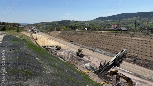 Construction of railway line LK104 with advanced ground stabilization and engineering structures. Geotechnical works including pile walls, soil reinforcement, ground nails, and slope protection system