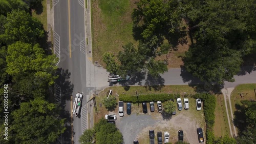 Two electrical utility trucks with lifts, driving on rural road arriving