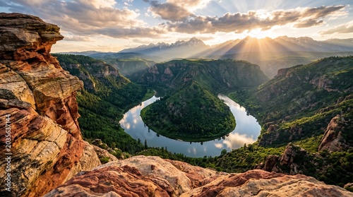 Cinematic landscape of a lush green canyon and river bend with dramatic sunbeams and red rock foreground
