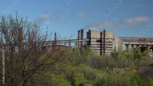 Industrial pellet production plant with railway infrastructure and moving rail signal near factory buildings. Handheld 4K footage of heavy industry and industrial landscape.