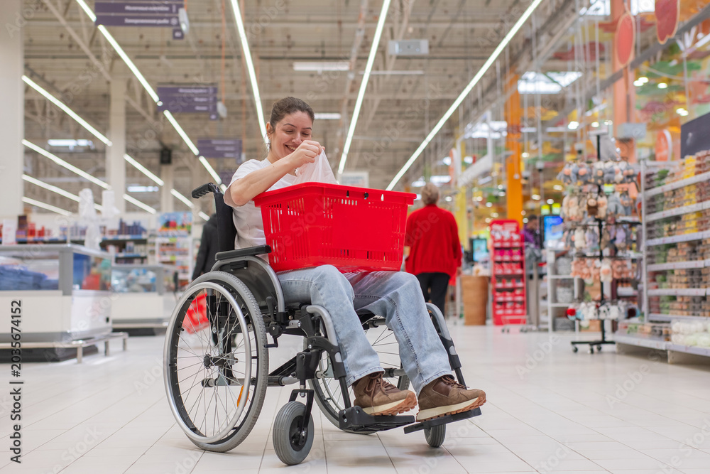 Obraz premium A Caucasian woman in a wheelchair buys fruit at a supermarket.