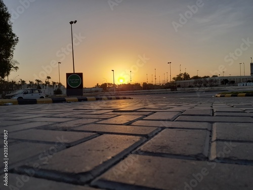 Canvas-taulu Stunning sunset view over a paved parking lot with a no exit sign and street lam