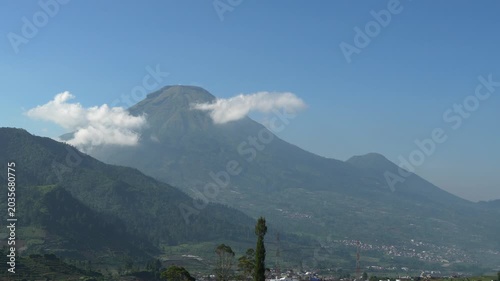 Scenic time-lapse of beautiful volcanic peak with fast-moving clouds in Dieng plateau area, majestic Indonesian nature landscape.