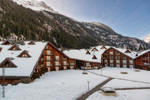 Φωτογραφία Snow covers the buildings of a resort surrounded by mountains on a winter mornin