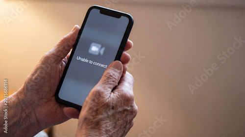 Senior woman hands holding smartphone displaying unable to connect error message. Internet blocking and communication failure on mobile device. Restricted social media access concept.