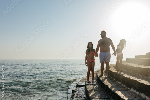 Foto Backlit Family Walking Along Seaside Steps at Sunset