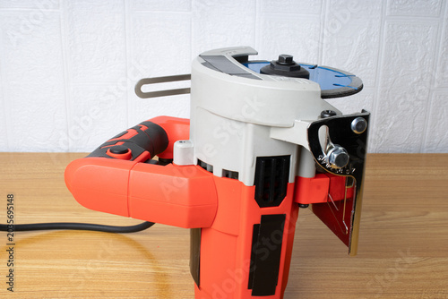 red electric saw on wooden table.