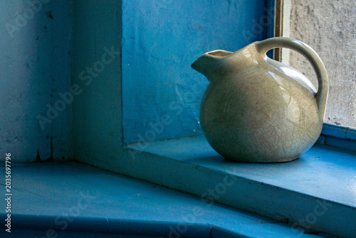 Bild auf Leinwand Ceramic Water Pitcher on Window Sill in Blue Room