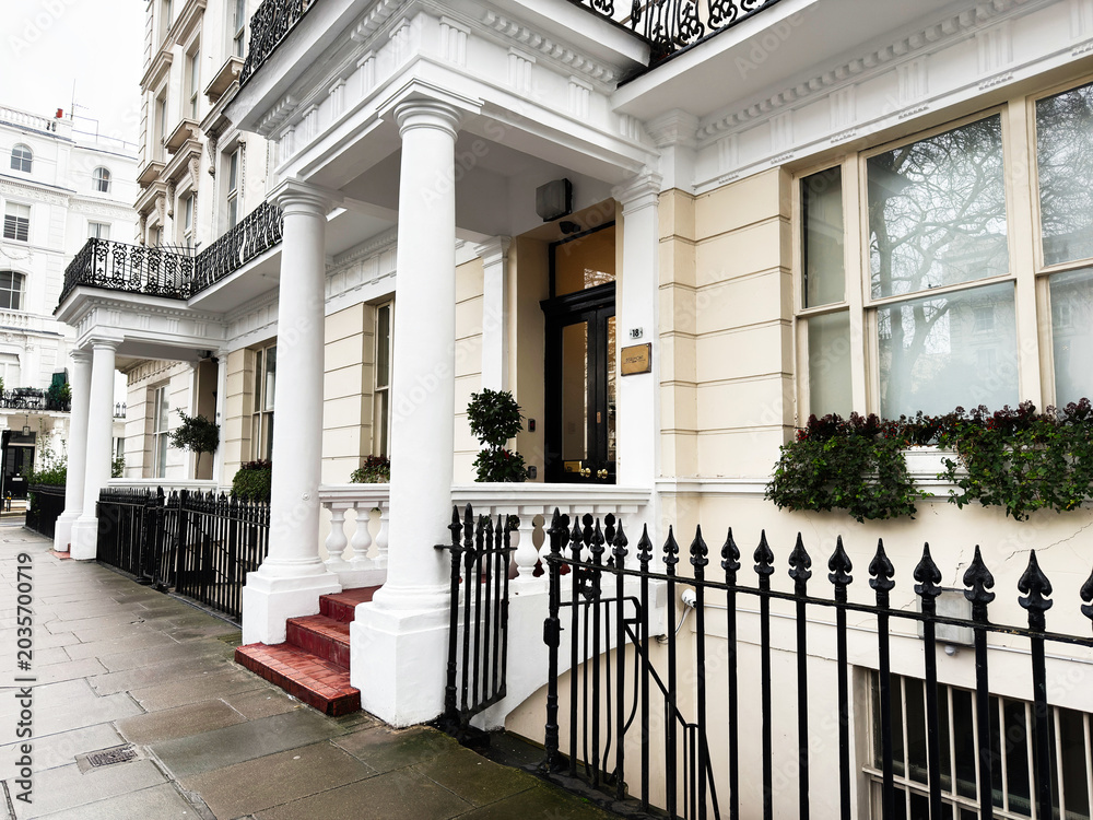 Fototapeta premium Elegant white terraced Beaumont House Hotel facade with columns and black railings in London, UK residential street