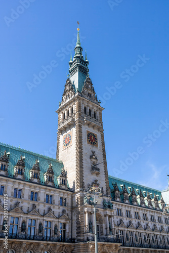 The majestic tower of Hamburg Town Hall rises against a vibrant blue sky, showcasing its neo-Renaissance architecture in Germany's historic city center.
